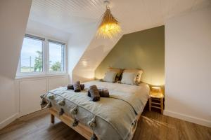 a bedroom with a large bed and a window at Lividig Bleue en face de la mer in Brignogan-Plage +26 photos