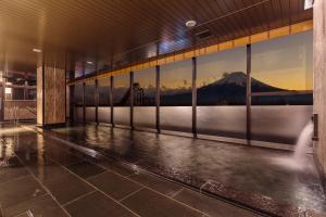 a building with a view of a mountain through windows at HOTEL MYSTAYS Fuji Onsen Resort in Fujiyoshida