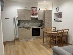 a kitchen with a wooden table and a dining room at Al Vicolo in Intra