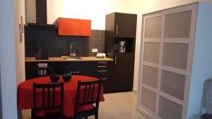 a kitchen with a red table and chairs and a kitchen door at Studio charmant avec jardin in Saint-Rémy-de-Provence