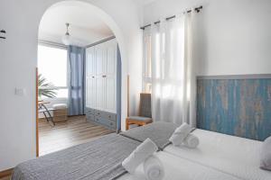a white bedroom with a bed and a chair at Las Golondrinas in Jedey