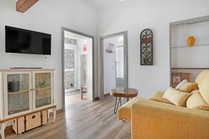 a living room with a couch and a tv on a wall at Las Golondrinas in Jedey
