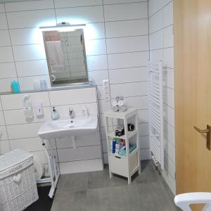 a white bathroom with a sink and a mirror at Eifelstube Langerwehe in Langerwehe +18 photos