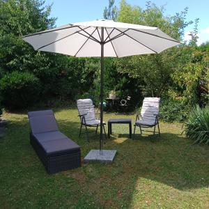 two chairs and a table with an umbrella at Eifelstube Langerwehe in Langerwehe