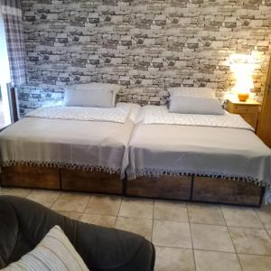 two beds in a room with a brick wall at Eifelstube Langerwehe in Langerwehe
