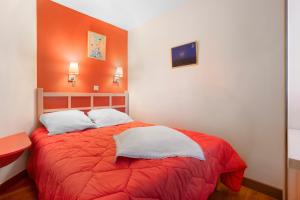 a bedroom with a red bed with white pillows at Appartement Cap Esterel St Raphaël in Saint-Raphaël +17 photos