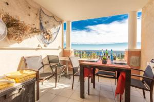 a balcony with a table and chairs and a view of the ocean at Appartement Cap Esterel St Raphaël in Saint-Raphaël