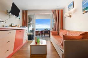 a living room with a couch and a table at Appartement Cap Esterel St Raphaël in Saint-Raphaël