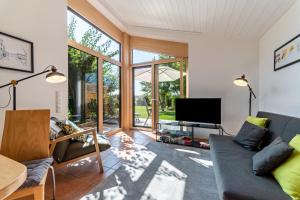 a living room with a couch and a tv at Naturnahe Ferienwohnung Deuerling in Deuerling