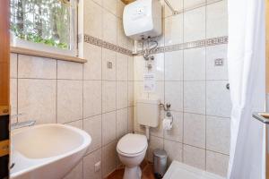 a small bathroom with a toilet and a sink at Bungalow 131 in Zeulenroda +13 photos
