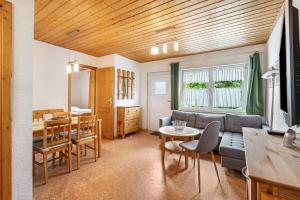 a living room with a couch and a table at Bungalow 131 in Zeulenroda
