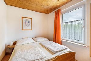 a bedroom with a bed and a large window at Bungalow 131 in Zeulenroda