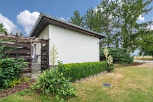 a white house with a fence next to a yard at Bungalow 131 in Zeulenroda