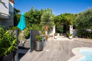 a patio with an umbrella and a swimming pool at Lucerta Bella in Aix-en-Provence