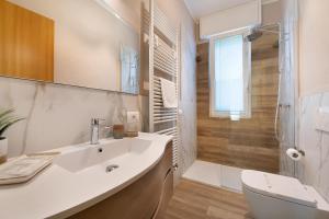 a white bathroom with a sink and a shower at Villa Iconi Lake Garda in Manerba del Garda +34 photos