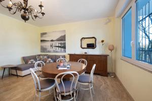 a dining room with a table and chairs and a couch at Villa Iconi Lake Garda in Manerba del Garda