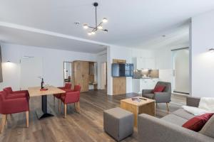 ein Wohnzimmer mit Tisch und Stühlen und eine Küche in der Unterkunft Hotel & Restaurant Lamm in Mosbach