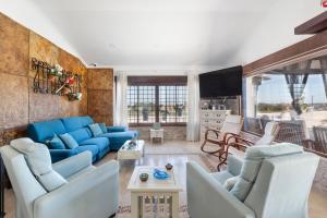 a living room with blue couches and a tv at Ecoturismo Calblanque in Las Barracas