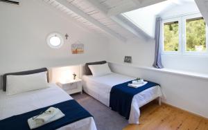 a bedroom with two beds and a window at Old Olive Press Sea and Mountain in Ágios Márkos +37 photos