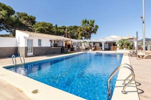 a swimming pool with blue water in front of a house at Ecoturismo Calblanque in Las Barracas