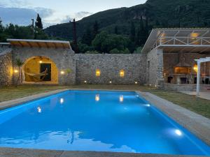 a large blue swimming pool in front of a stone building at Old Olive Press Sea and Mountain in Ágios Márkos