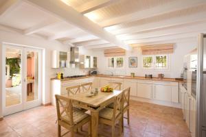 a kitchen with a wooden table and chairs at Old Olive Press Sea and Mountain in Ágios Márkos