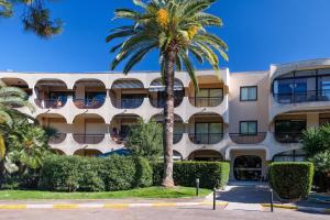 a palm tree in front of a building at Studio Riviera de Bahia in Villeneuve-Loubet