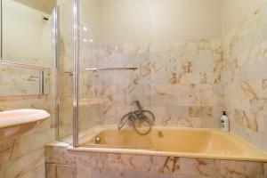 a bath tub with a shower and a sink in a bathroom at Studio Riviera de Bahia in Villeneuve-Loubet +28 photos