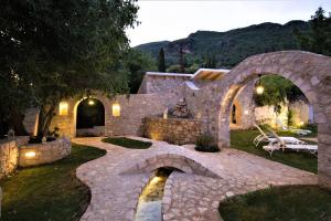 a stone house with a stone bridge in a yard at Old Olive Press Sea and Mountain in Ágios Márkos