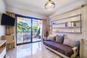 a living room with a couch and a balcony at Studio Riviera de Bahia in Villeneuve-Loubet