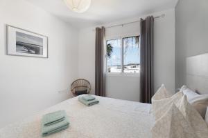 a bedroom with a bed with two towels on it at casa agua y sol 2 in Poris de Abona +24 photos