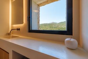 a bathroom with a window and a white apple on a counter at Casa La Petite in San Pantaleo +34 photos