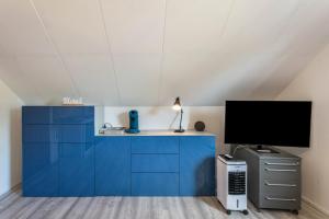 a room with a blue cabinet and a tv at Ferienwohnung Ostseeclick in Damp