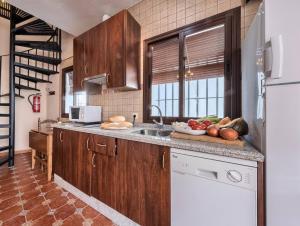 a kitchen with wooden cabinets and a counter with fruits and vegetables at Los Placeres Del Paladin in Zufre +16 photos