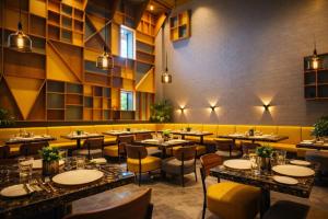 a restaurant with tables and chairs in a room at The Weekend Address Managed By Stayzy in Dumas