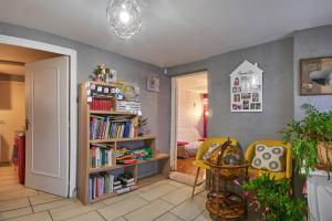 a living room with a book shelf filled with books at Studio in Saint-Victor-de-Cessieu
