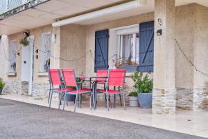 a group of red chairs and a table on a porch at Studio in Saint-Victor-de-Cessieu