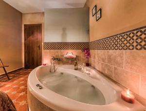 a large bath tub in a bathroom with two candles at Los Placeres Del Paladin in Zufre