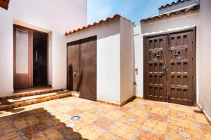 an empty room with two doors and a tile floor at Los Placeres Del Paladin in Zufre