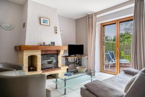 a living room with a fireplace and a tv at Gite Palombe in Lanvallay