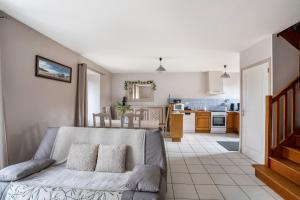 a living room with a couch and a kitchen at Gite Palombe in Lanvallay