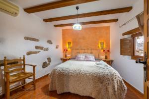 a bedroom with a bed and a chair in a room at C´antonia Y Manuel in Laroya +22 photos