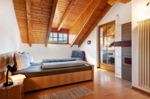 a bedroom with a bed in a room with wooden ceilings at Melcherhof in Trodena