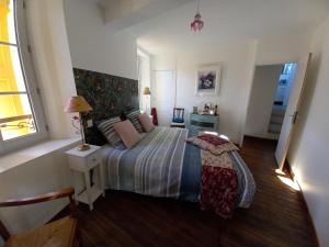 a bedroom with a bed and a table and a window at Chambre Bleue - Ostau la Lutz in Saint-Germain-de-Calberte