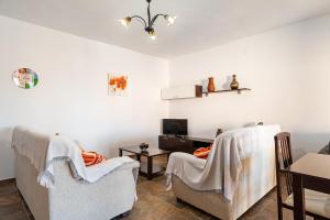 a living room with two chairs and a tv at Chalet Rocío - solo familias in Conil de la Frontera