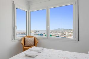 a room with a table and two windows with a view at Vora Port in L'Ampolla