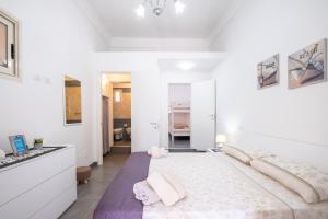 a white bedroom with a large bed and a sink at Casa Vacanze Lu Rizzaru in Nardò