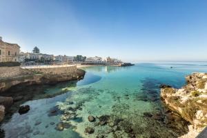 a view of a beach with blue water and buildings at Casa Vacanze Lu Rizzaru in Nardò