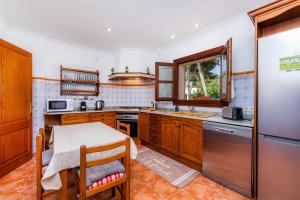 a kitchen with a table and a refrigerator at Na Forana in Cala Ratjada +16 photos