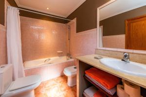 a bathroom with a sink and a toilet and a tub at Na Forana in Cala Ratjada